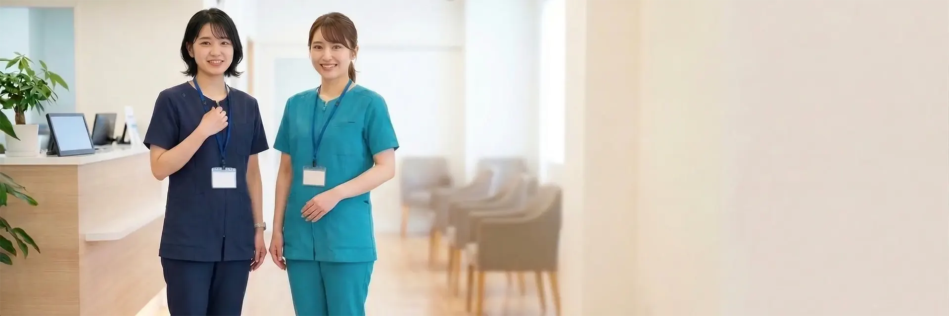 歯科衛生士向けスクラブ特集 ネイビーとターコイズのスクラブを着用したスタッフ2名